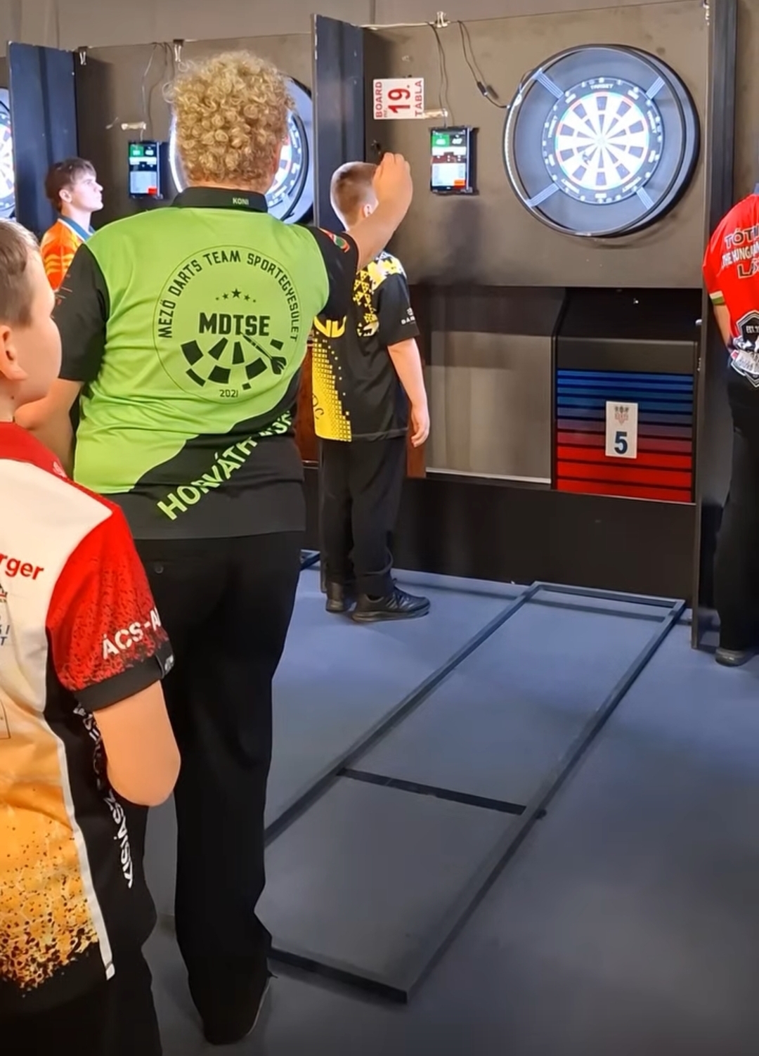 Nálunk Istenmezején nemcsak a mának, hanem a holnapnak is játszunk. 2026-ban különös figyelmet fordítunk az utánpótlás-nevelésre, hiszen hiszünk abban, hogy a következő generáció tehetségei nálunk találhatják meg az útjukat a profi darts világába. Legyen szó a technika finomításáról, a koncentráció fejlesztéséről vagy a versenyrutin megszerzéséről, az MDTSE-ben a fiatalok is professzionális környezetben, PC-vel felszerelt pályákon és tapasztalt mentorok mellett fejlődhetnek. Számunkra az a legnagyobb siker, ha látjuk a lelkesedést egy-egy tökéletes 140-es vagy egy magabiztos kiszálló után.